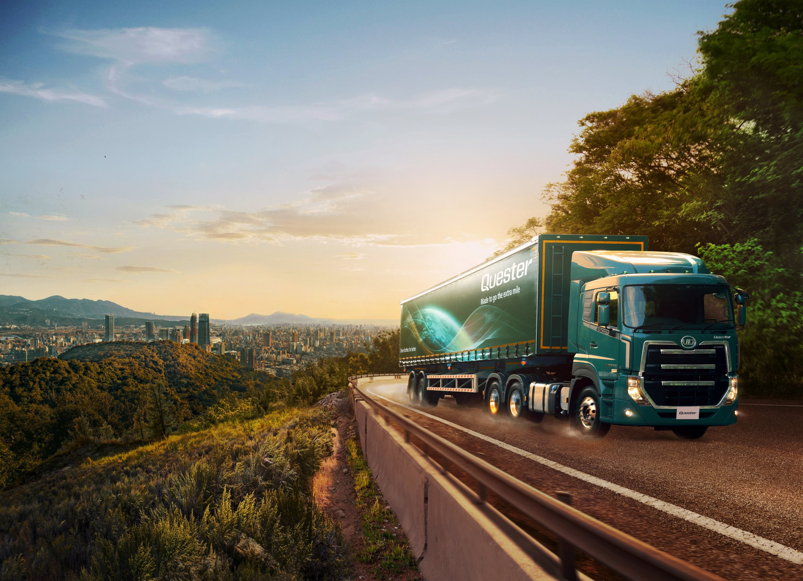 Lori ya kijani inaendesha barabarani karibu na mji wakati wa jua kuchomoza.