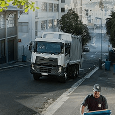 Lori sampah putih di jalan bandar, pekerja mengangkut tong biru.