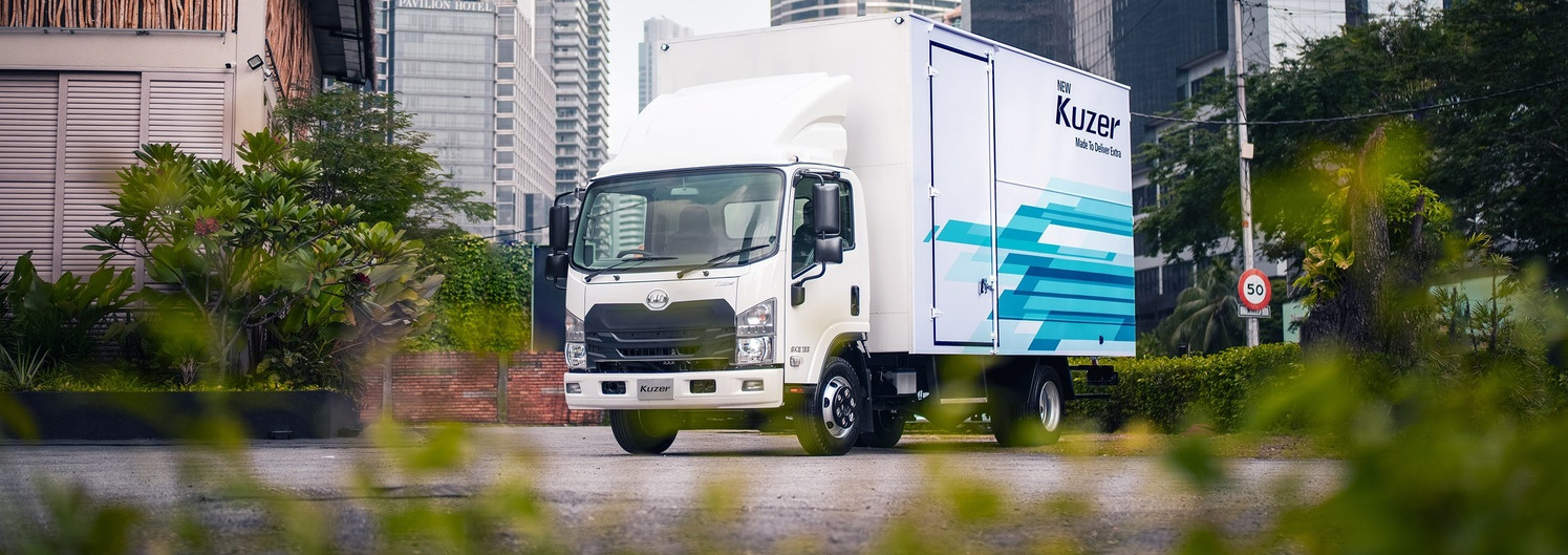 Delivery truck on urban street with tall modern buildings in the background