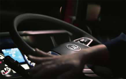 夜間、運転席でハンドルを握る手