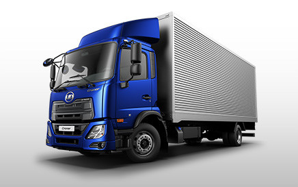 Blue semi-truck with a large silver cargo trailer on a plain background.