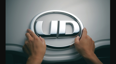両手でUDのロゴエンブレムを持つ様子