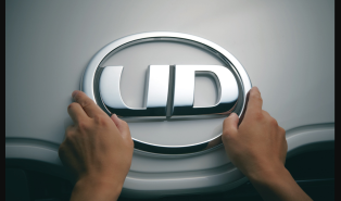 両手でUDロゴエンブレムを掴んでいる様子